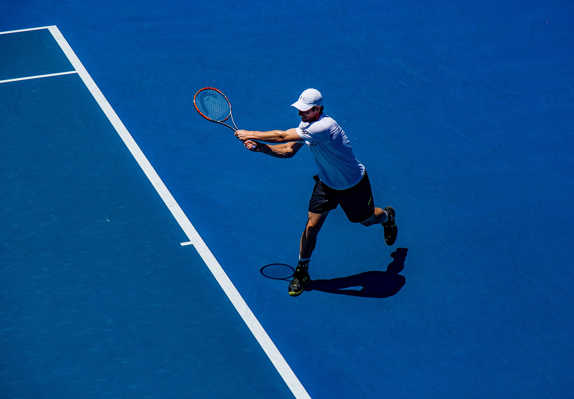 Tennis player mid-swing on court